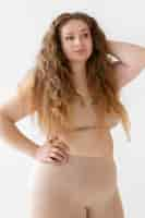 Free photo front view of confident woman posing while wearing a body shaper