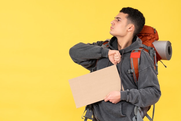 Front view confident young man with red backpack holding cardboard