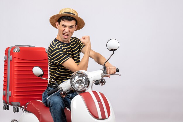 팔 근육을 보여주는 오토바이에 밀짚 모자와 자신감 젊은 남자의 전면보기