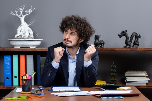 Free photo front view confused businessman sitting at the desk