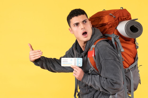 Front view confused traveller man with backpack holding plane ticket