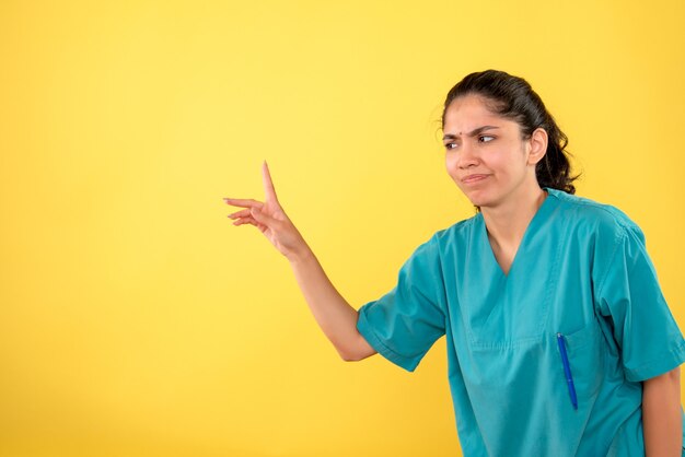 Free photo front view confused young female doctor on yellow background