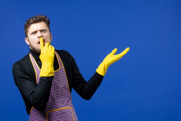 Front view confused young man putting finger on his mouth 