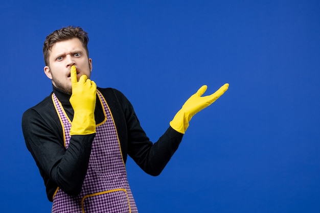 Front view confused young man putting finger on his mouth 