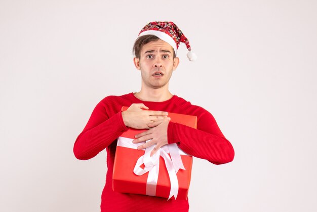 Front view confused young man with santa hat standing on white 