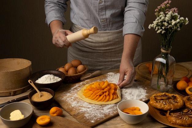 Free photo front view cook making pie