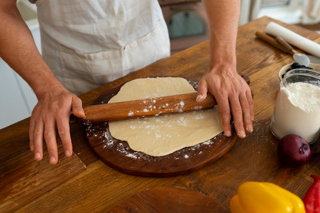 Foto gratuita cuoco di vista frontale che prepara pizza