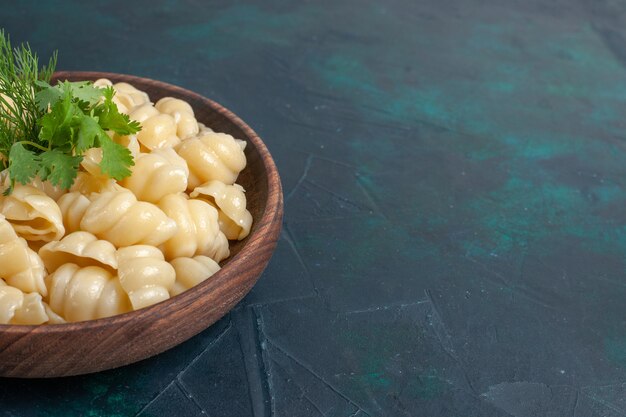 Front view cooked dough pasta with greens inside plate on dark surface