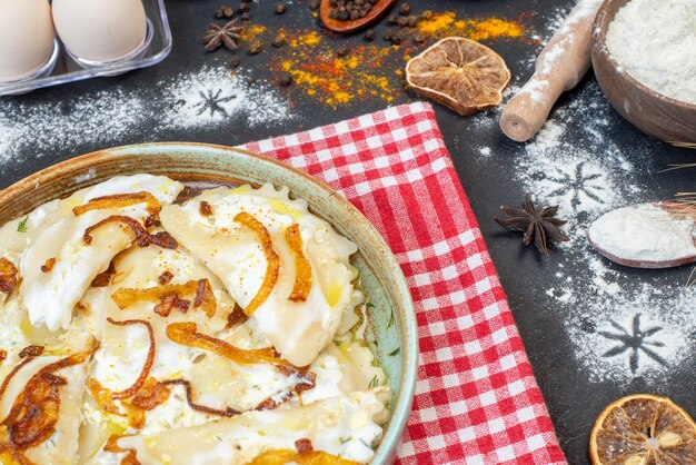 Front view cooked dough pieces with fried onions and different ingredients on dark background meal pepper food oil cooking photo dish