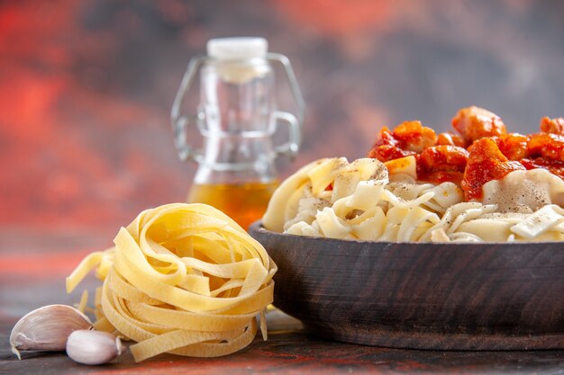 Front view cooked dough with sauce meat on dark floor dark pasta dough dish