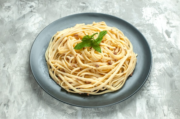 正面は、白い背景の上の皿の中のイタリアン パスタを調理しました。