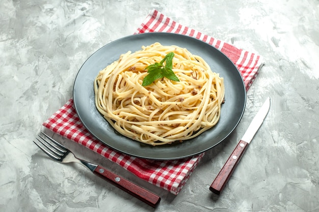 Front view cooked italian pasta with cutlery on white background