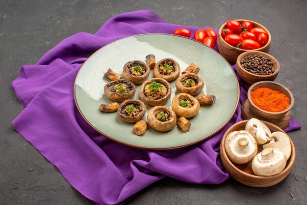 Front view cooked mushrooms inside plate with seasonings on purple tissue dish meal cooking mushroom dinner