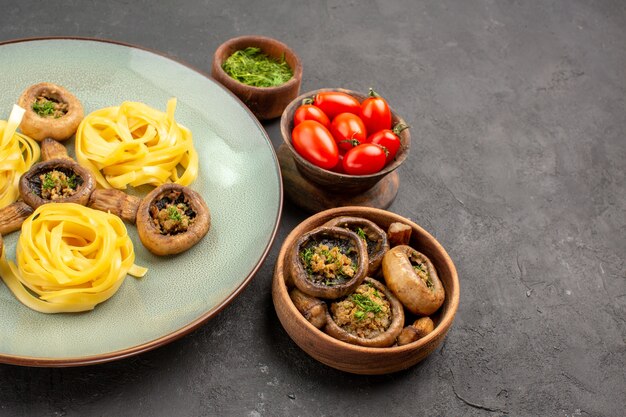 Вид спереди приготовленные грибы с макаронами из теста на темном столе, блюдо, ужин
