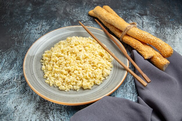 Front view of cooked pearl barley with bread on light surface