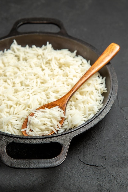 Front view cooked rice inside pan on dark desk meal food rice eastern dinner