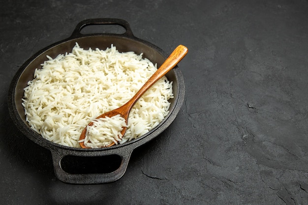 Front view cooked rice inside pan on the dark surface meal food rice eastern dinner