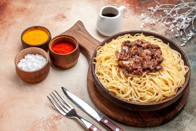 Front view cooked spaghetti with ground meat on light table dish pasta dough meat