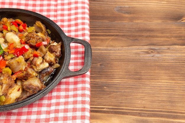 Front view cooked vegetable meal including vegetables and meat inside on wooden brown desk