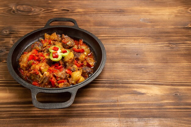 Front view cooked vegetable meal inside pan on brown desk