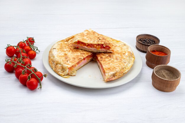 흰색 표면에 신선한 빨간 토마토와 하얀 접시 안에 요리 야채 과자의 전면 모습