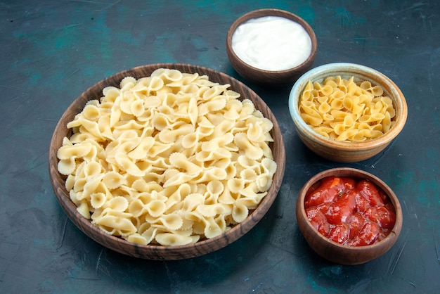 Приготовленная итальянская паста с соусом на синем столе, вид спереди