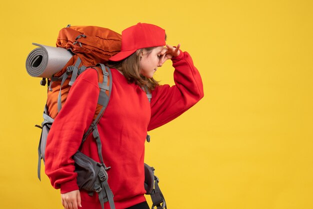 Front view cool female traveler with backpack holding nose