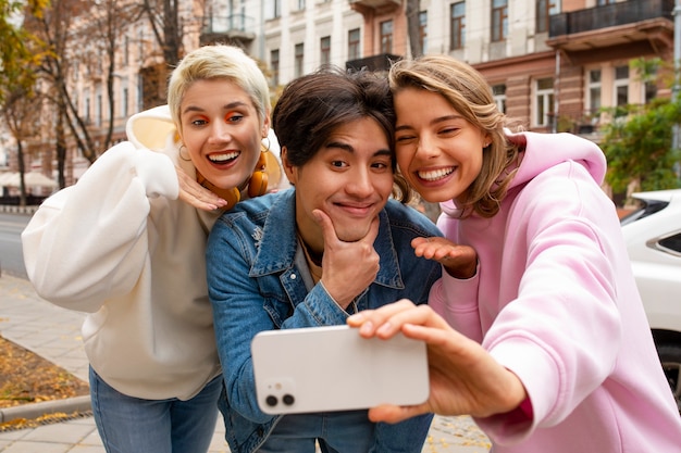 Free photo front view cool friends taking selfie together