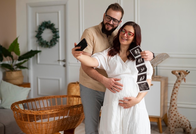Front view couple announcing pregnancy with smartphone