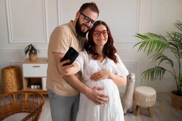 Пара вид спереди объявляет о беременности со смартфоном