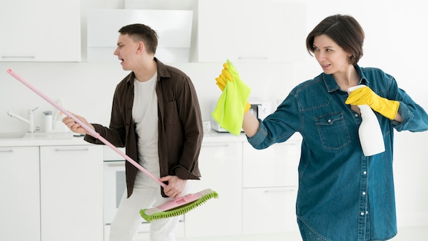 Free photo front view of couple cleaning the house