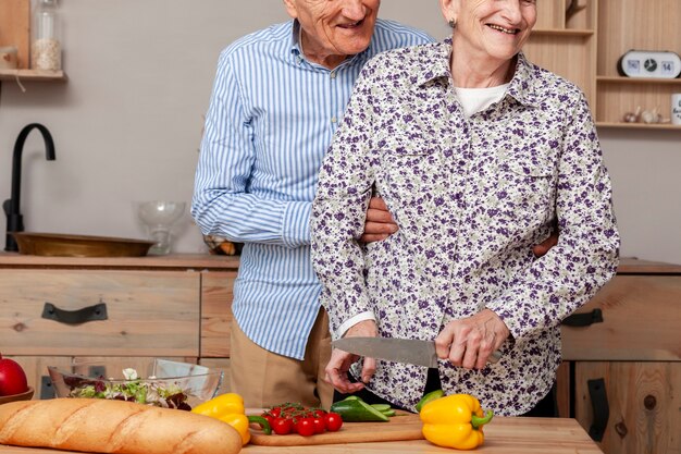 Front view couple cutting vegetables