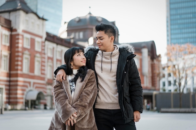 Front view of couple embraced outdoors in the city