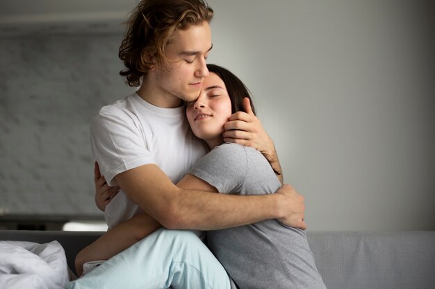 Front view of couple embracing in bed