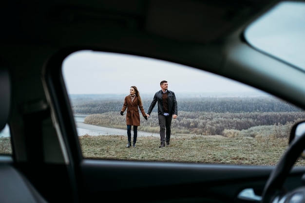 Front view of couple holding hands from the inside of car