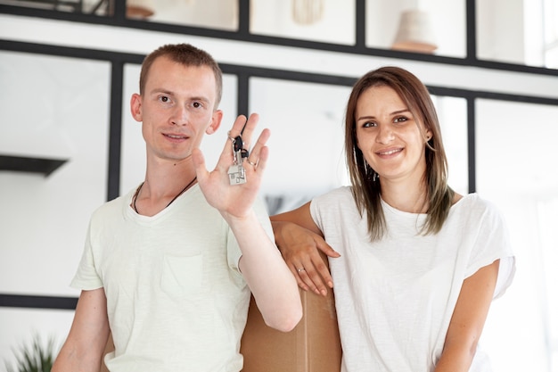 Front view couple holding a key for their new house