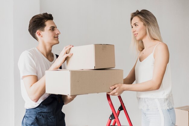 Front view couple holding moving boxes