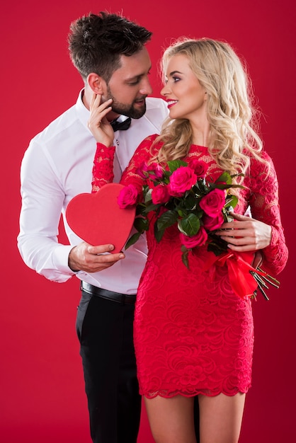 Front view of couple holding Valentine's Day symbols