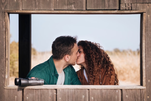 正面のカップルが避難所を見ている鳥にキス