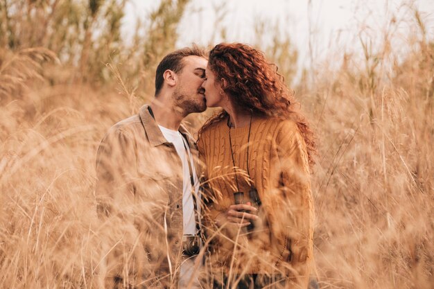 正面のカップルが麦畑の中でキス