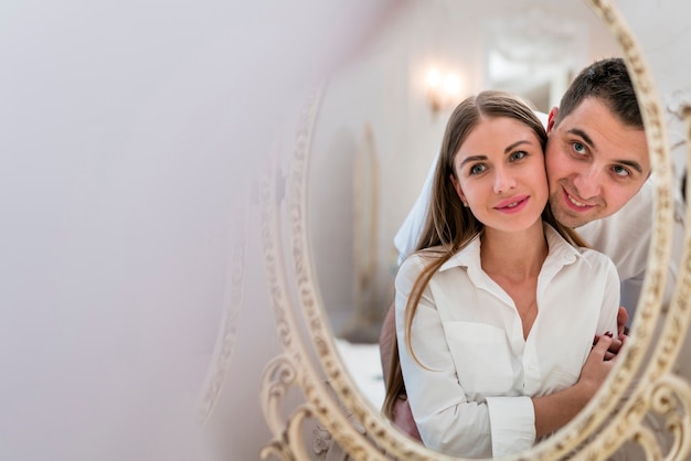 Front view of couple looking in the mirror with copy space