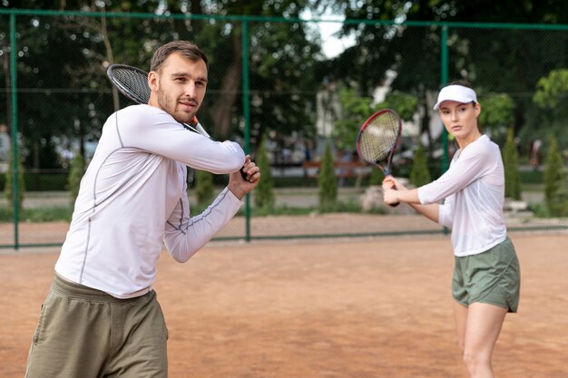 Front view couple playing tennis