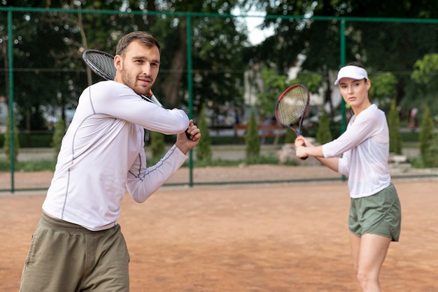 Front view couple playing tennis