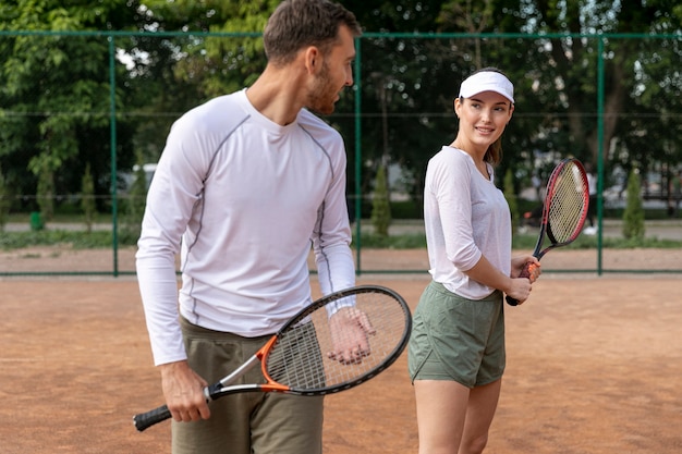 Front view couple playing tennis