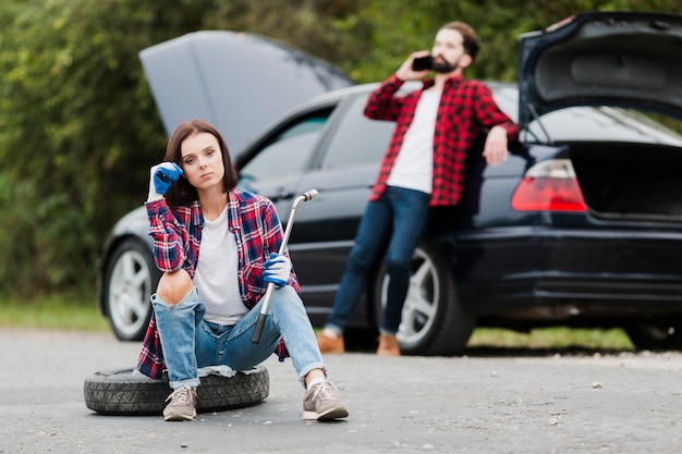 Front view of couple repairing car