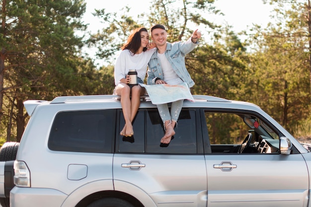 Front view couple sitting on car