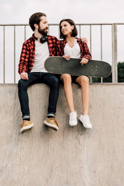 Free photo front view of couple sitting on a ramp