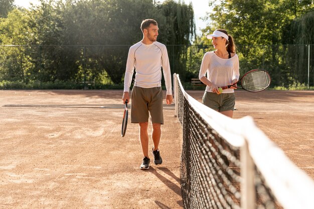 Front view couple on tennis court