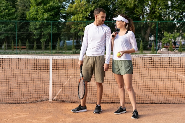 Front view couple on tennis court