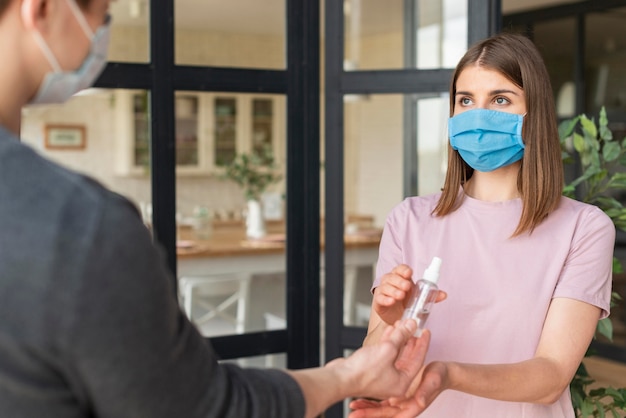 Foto gratuita vista frontale della coppia utilizzando disinfettanti